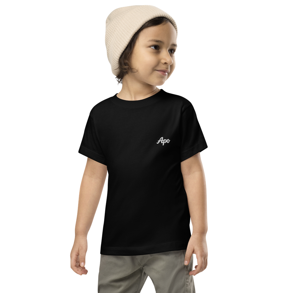 Toddler in a beanie wearing a black Apo (Grandchild) toddler t-shirt with white embroidered name on the left chest